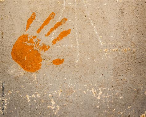 Human Hand Print In Orange Color On Old Plaster Wall Texture Surface