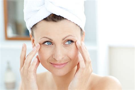 Premium Photo Smiling Young Woman Putting Moisturizer On Her Face