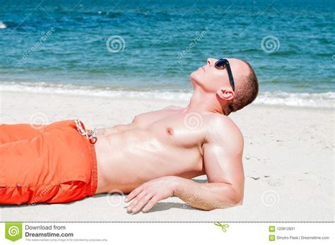 Jeune Homme Sexy Sportif Musculaire Se Trouvant Sur La Plage Image