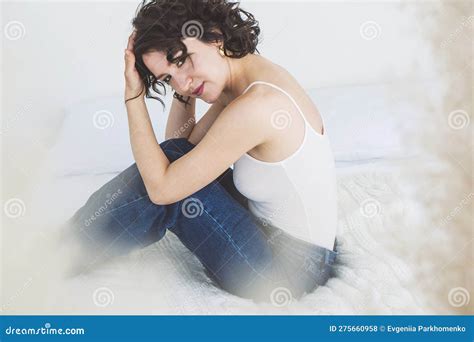 Eine Brunette Mit Lockigem Haar Sitzt Auf Dem Bett Und Umarmt Ihre Knie