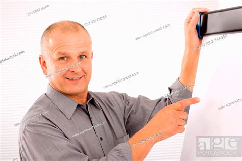 Mature Businessman Pointing At Empty Flip Chart Stock Photo Picture