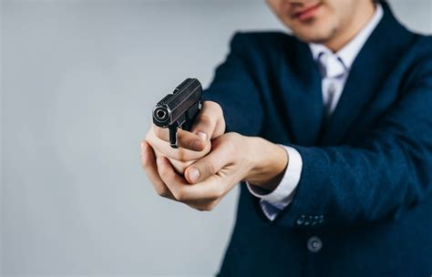 Premium Photo Close Up Of Businessman Holding A Gun