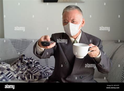 Mature Japanese Businessman With Mask Staying At Home Under Quarantine