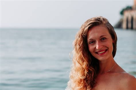 Belle Dame En Bikini Bandeau Debout Et Souriant Dans La Mer Pendant La Journée Photo Gratuite
