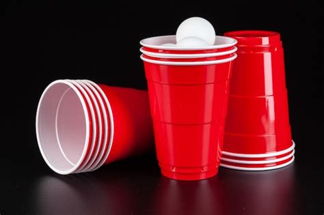 Premium Photo Red Plastic Cups And Ball For Game Of Beer Pong