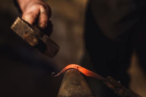 Premium Photo Blacksmith Makes An Artistic Forging Of Hot Metal On The Anvil