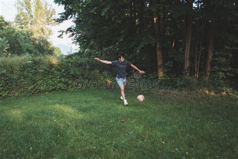 Black Haired Athlete Plays A Friendly Football Match On The Lawn Amateur Sport Man Playing