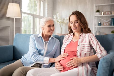 Smiling Blonde Haired Mature Woman Sitting Near Pregnant Niece Stock