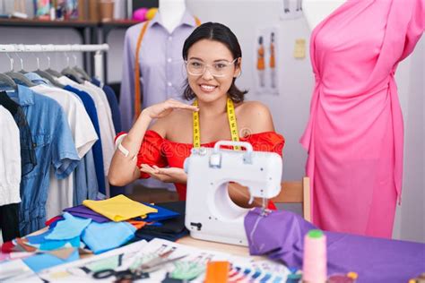 Hispanic Young Woman Dressmaker Designer Using Sewing Machine Gesturing