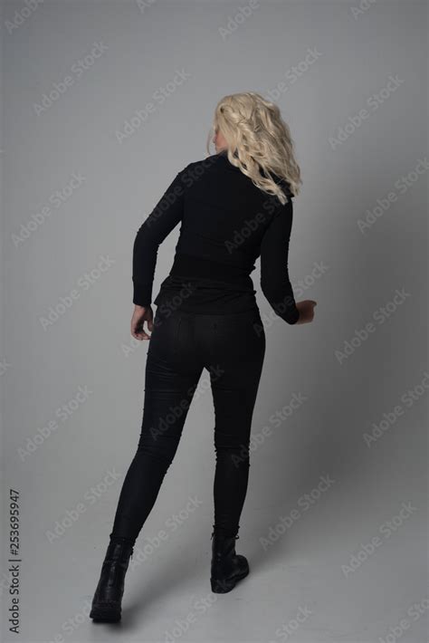 Full Length Portrait Of A Blonde Girl Wearing Modern Black Jacket And Pants Standing Pose
