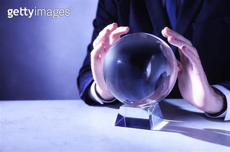 Businessman Using Crystal Ball To Predict Future At Table Closeup