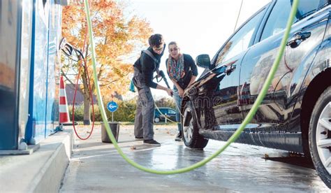 Service Man Helping Woman Cleaning Her Auto In Car Wash Stock Photo