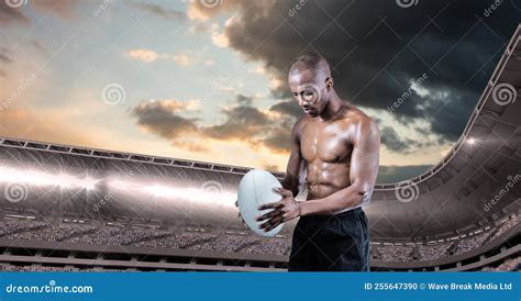 Composition Of Shirtless Male Rugby Player Holding Rugby Ball Over