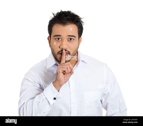 Closeup Portrait Of Young Serious Man Placing Finger On Lips As If To