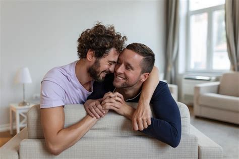 Feliz casal gay deitado na cama em casa abraçando e flertando casal gay LGBT amam momentos