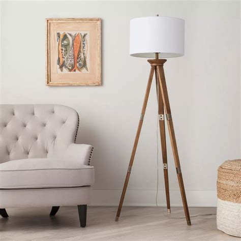 A Tripod Floor Lamp With Brass Accents That’ll Add A Modern Touch To Your Living Space