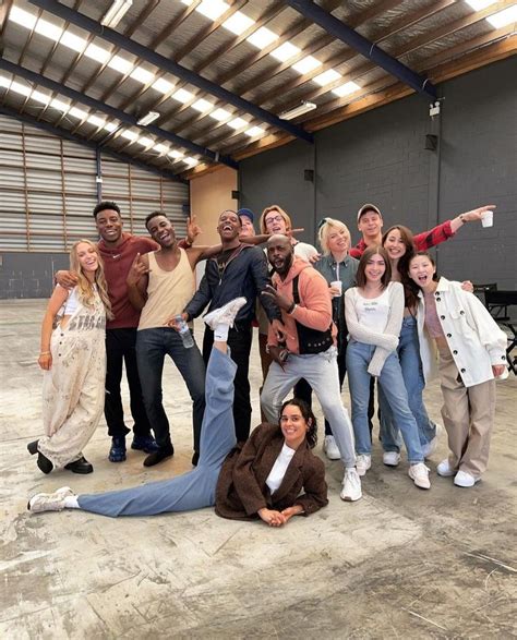 A Group Of People Standing And Laying On The Ground Posing For A Photo