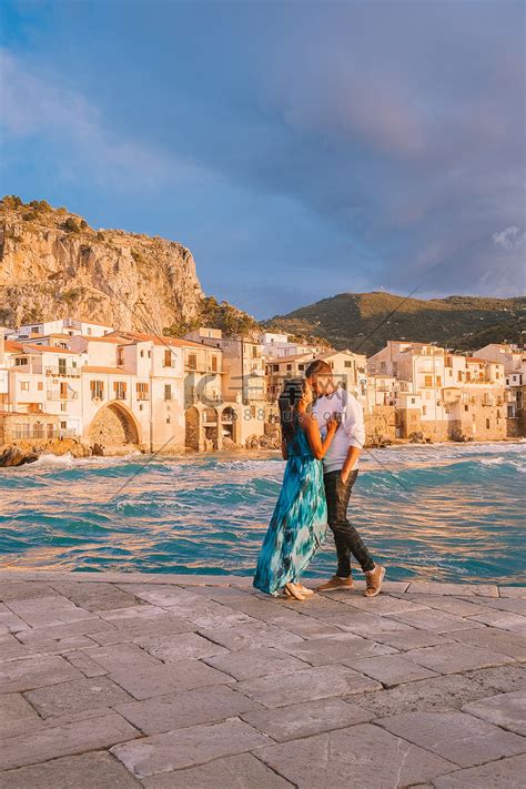 Cefalu Sicily，一对夫妇在意大利 Cefalu Sicilia 的海滩看日落，中年男女在西西里岛度假高清摄影大图 千库网