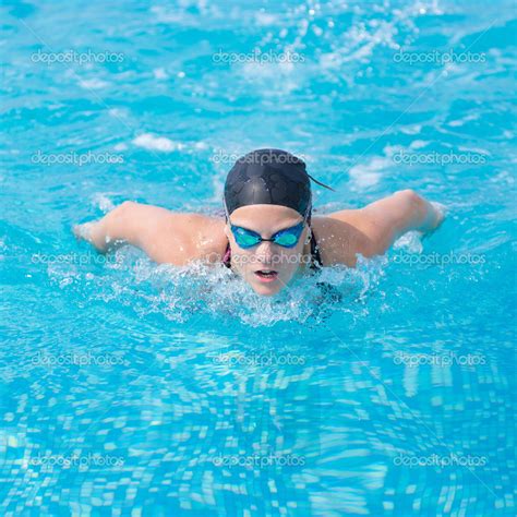 Young girl swimming butterfly stroke style Stock Photo by ©markin 32889087