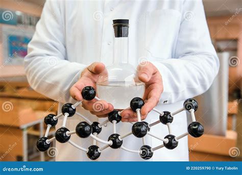 Scientist In A White Lab Coat Putting Vial With A Sample Into