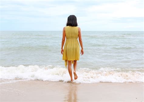 Premium Photo | Young woman walking alone on the beach