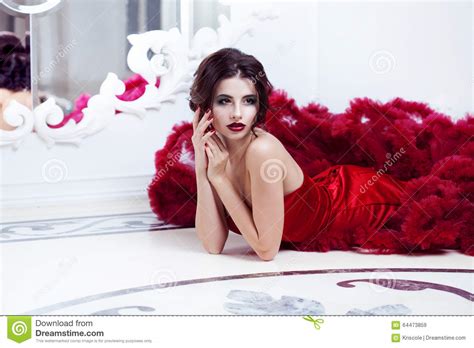 Πρότυπη γυναίκα Brunette ομορφιάς στο κόκκινο φόρεμα βραδιού Στοκ