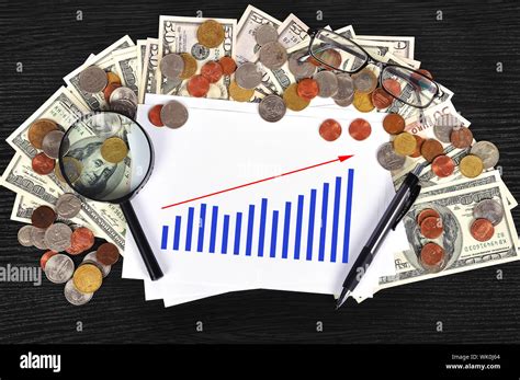 money on table and paper with chart Stock Photo - Alamy