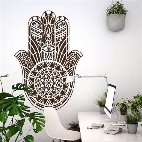 A Desk With A Computer And Potted Plants On It In Front Of A Hamsa Wall