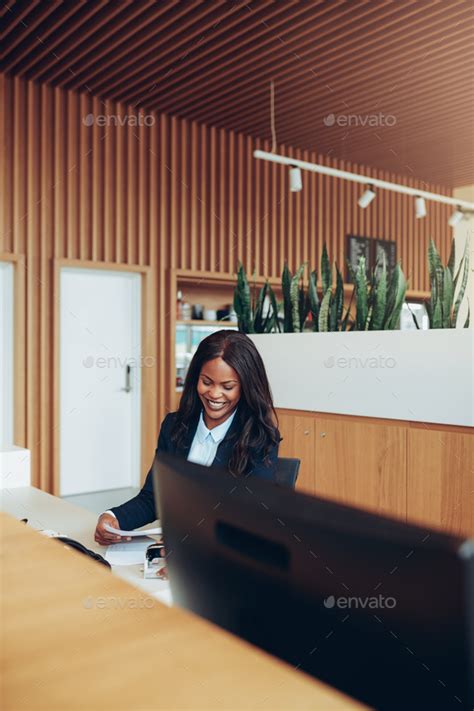 Smiling African American Businesswoman Sorting Paperwork At A Reception