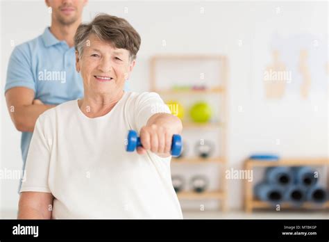 Elderly Woman Doing Active Isometric Exercises Guided By Physical