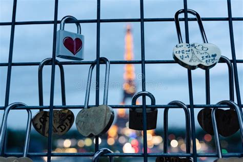 Illuminated Eiffel Tower Is Seen At Night Behind Fence Filled With