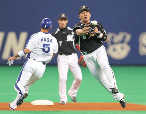 （朝日新聞社）：【中日―ロッテ】1回裏中日2死一、二塁、野本の二ゴロを一塁へ悪送球する井口（右）。左は一塁走者和田＝長島一浩