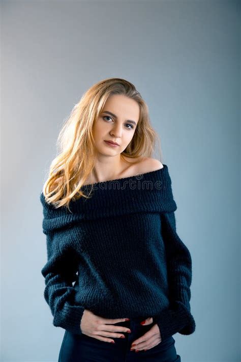 Ritratto Della Giovane Signora Affascinante Che Posa In Pullover Nero Con Le Spalle Nude Sopra