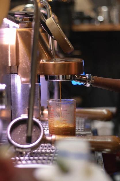 Um barista usa uma máquina de café para fazer café em uma cafeteria e