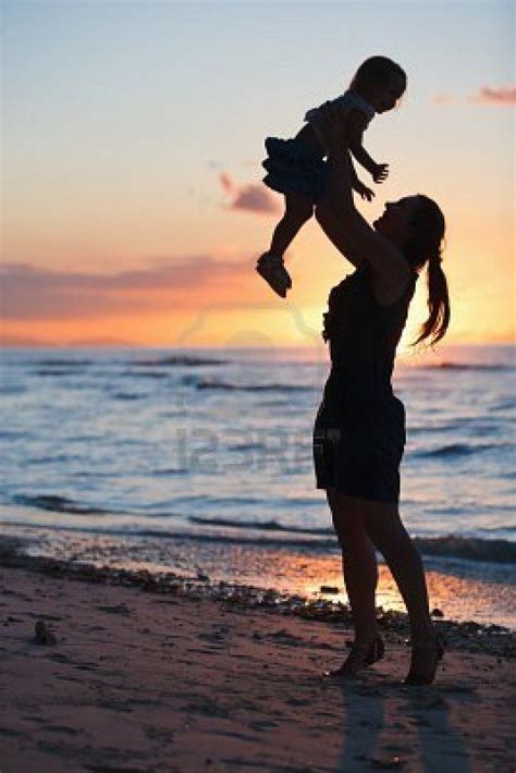 Mother And Daughter Silhouettes On Beach At Sunset Silhouette