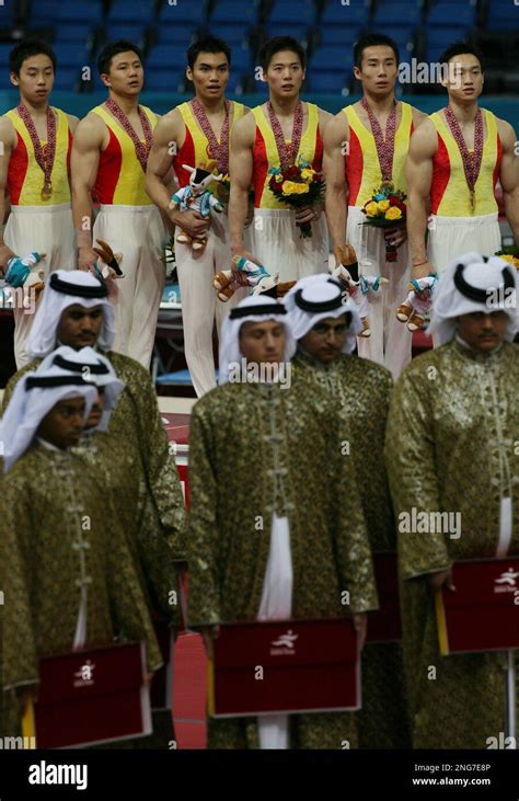 Chinese Men S Gymnastic Team Stands At Attention On The Podium After Winning The Gold Medal In