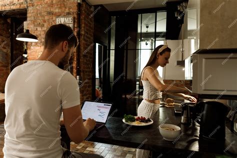 Premium Ai Image Woman Cooking Food In The Kitchen And The Man Sits