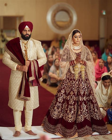 Indian Bride And Groom In A Coordinated Maroon Velvet Wedding Lehenga