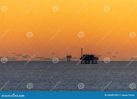 Offshore Drilling Platforms During Sunset In The Gulf Of Mexico Stock