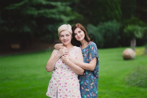 Mother And Adult Daughter In A Green Park Posing Together Stock Image