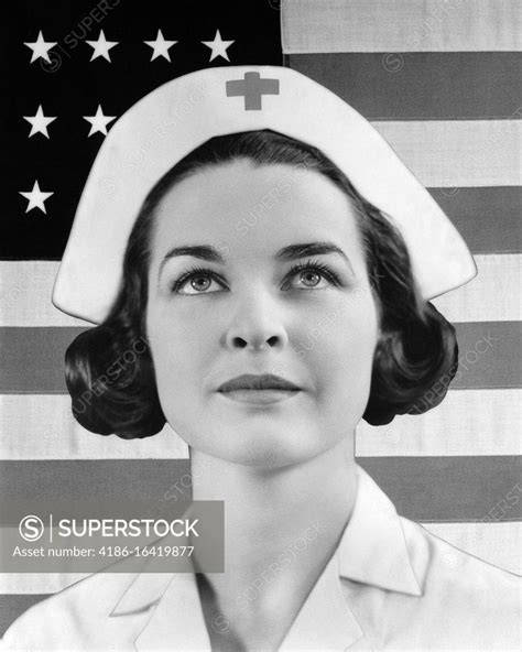 1930s 1940s PORTRAIT OF RED CROSS NURSE LOOKING UP WITH UNITED STATES