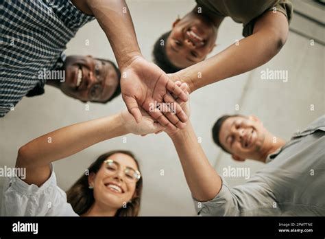 Cheerful Group Of Colleagues Putting Hands Together In The Office