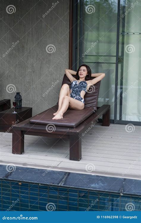 Mulher Que Relaxa Em Uma Cadeira Na Piscina Foto De Stock Imagem De