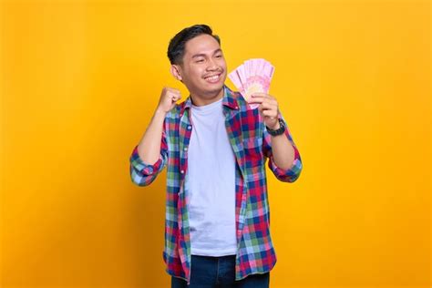 Premium Photo Excited Young Asian Man In Plaid Shirt Holding Money