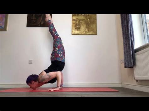 a person doing a handstand on a yoga mat