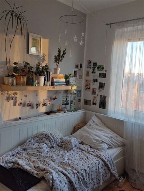 An Unmade Bed Sitting Next To A Window In A Room Filled With Pictures