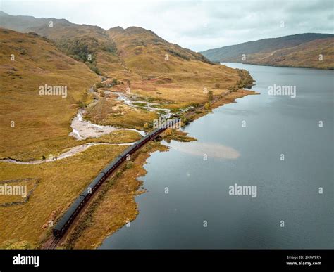 Steam Train Passing By a Loch in the Scottish Highlands Stock Photo - Alamy