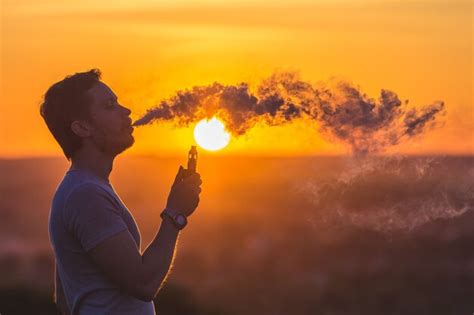 Premium Photo The Man Smoke An Electrical Cigarette On The Background