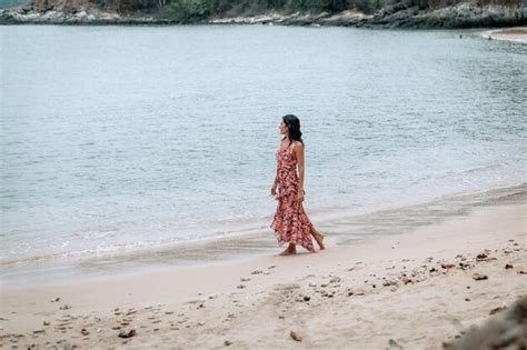 Une jeune fille orientale se promène seule le long de la plage en