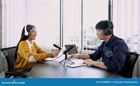 Asian Woman Radio Hosts Gesturing To Microphone While Interviewing A